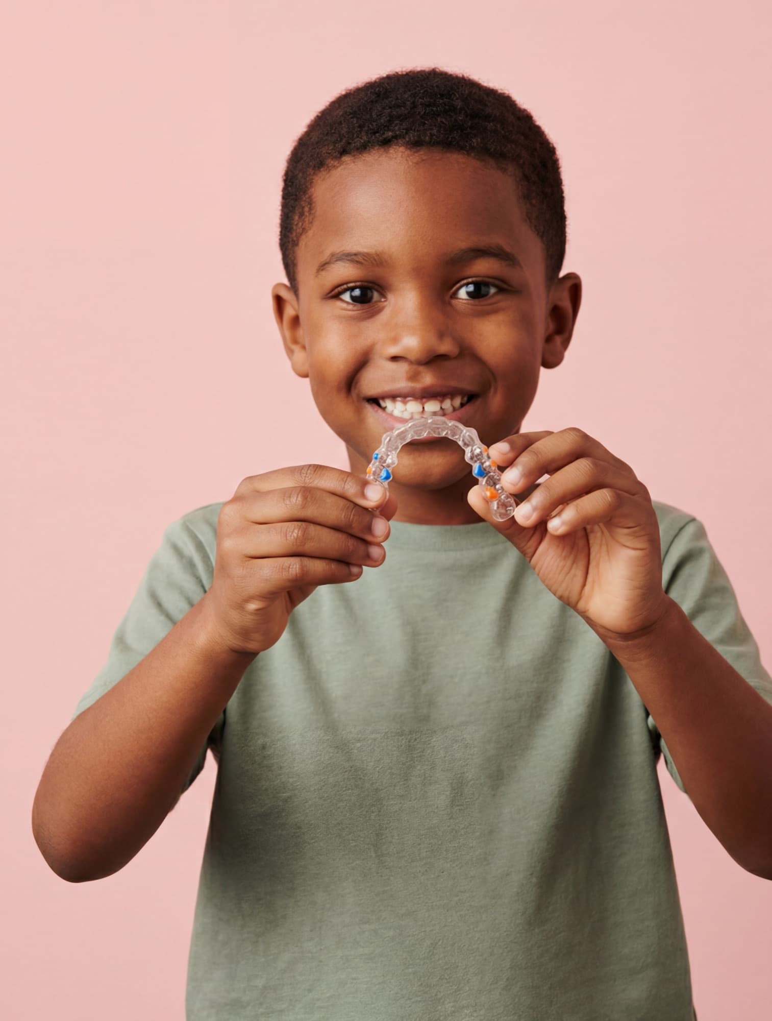 Child holding a clear aligner